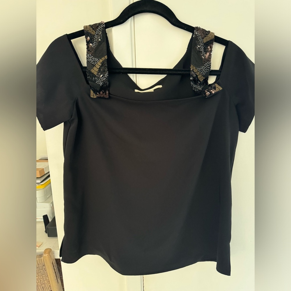 Black top with sequins shoulder straps.